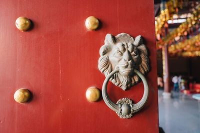 Close-up of statue against red door