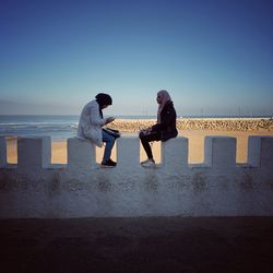 Friends on sea against sky