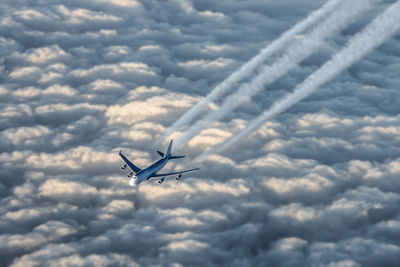 Airplane flying in cloudy sky