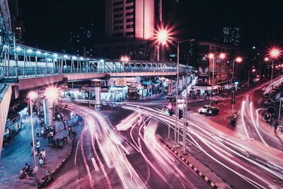 High angle view of light trails over street by bridge at night