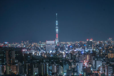 Illuminated cityscape against sky at night