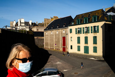 Full length of woman on road amidst buildings in city