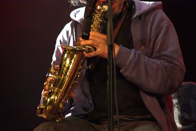 Midsection of man playing music at concert