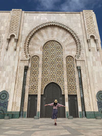 Rear view of woman standing outside temple