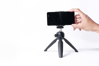 Low angle view of person photographing against white background