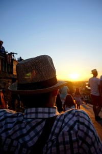 Rear view of people against clear sky during sunset