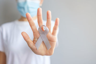 Midsection of woman holding gift against blue background