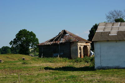 Abandoned house on field against clear sky