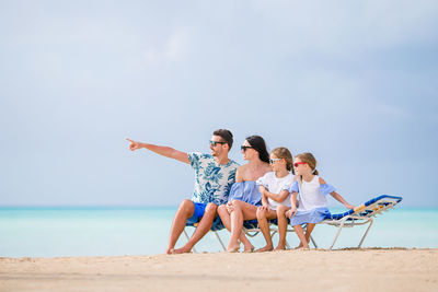 Children on beach against sky