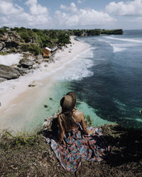 Rear view of woman sitting on beach