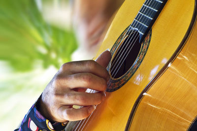 Cropped hand of man playing guitar