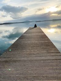 Pier over sea against sky during sunset