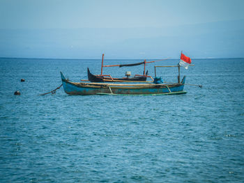 Fishing boat in sea against sky