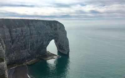 Rock formation in sea against sky