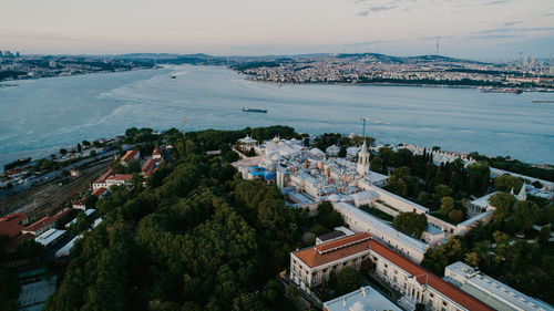 High angle view of townscape by sea against sky