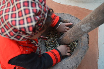 High angle view of baby girl sitting by stone bowl