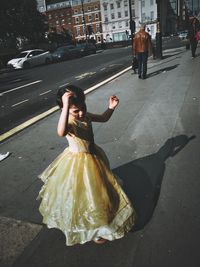 Woman with umbrella on street in city