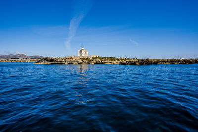Lighthouse on the coast with blue water in the island of favignana in trapani sicily italy