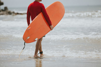 Close-up of man with red umbrella at beach