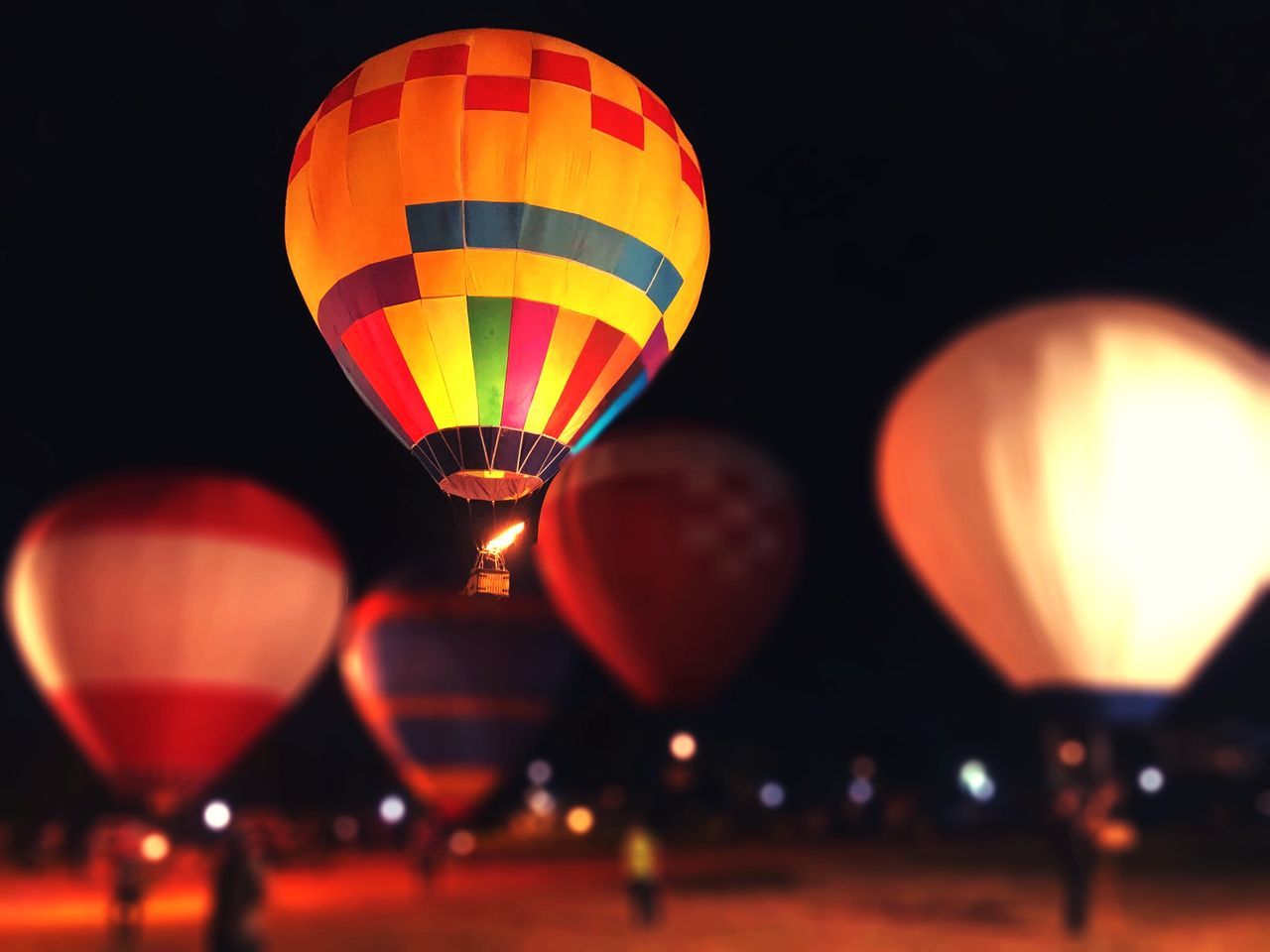 hot air balloon, illuminated, air vehicle, multi colored, no people, night, balloon, celebration, transportation, glowing, orange color, fire, lighting equipment, flying, ballooning festival, focus on foreground, nature, burning, outdoors, glass