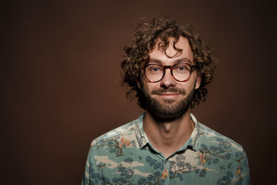 Portrait of smiling man against brown background