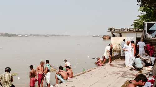 People at beach against clear sky