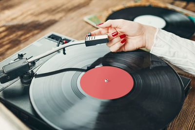 Young woman listening to music from vinyl record player. playing music on turntable player. vintage