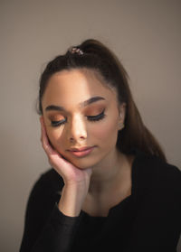 Portrait of young woman against wall