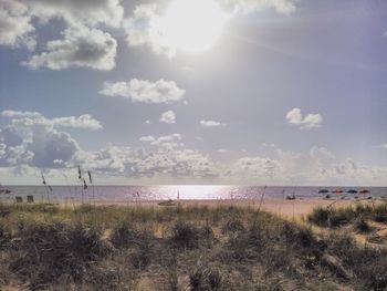Scenic view of beach against cloudy sky