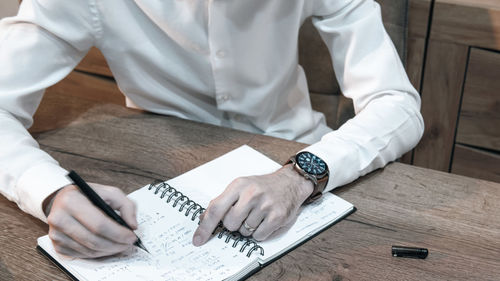 Midsection of man working on table