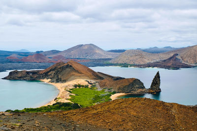 Scenic view of valcanoes, volcanoe island, beach, surrounded by the ocean, mountains against sky