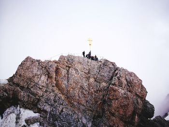 Low angle view of man on rock against sky