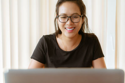 Smiling young woman using laptop