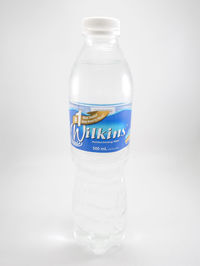 Close-up of glass of bottle against white background
