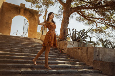 Low angle view of smiling woman walking on steps