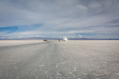 Distant group of tourists on bolivian salt flat