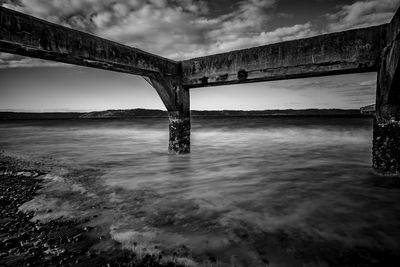 View of wooden post in sea against sky