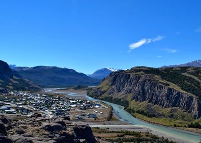 Scenic view of landscape and mountains against blue sky