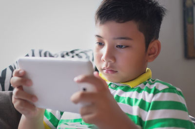 Close-up of boy holding digital tablet at home