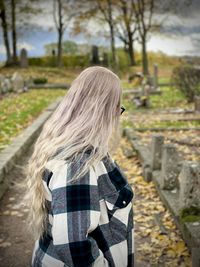 Rear view of woman standing against tree