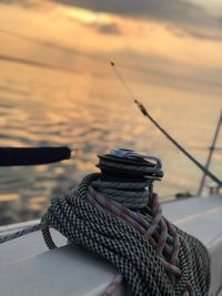 Rope tied on boat at sea during sunset