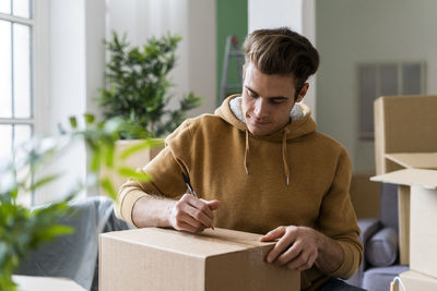 Young man sitting in box