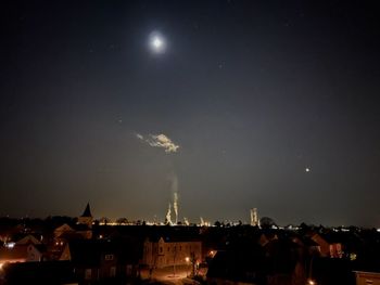 Silhouette buildings against sky at night