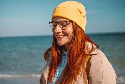 Portrait of young woman standing at beach
