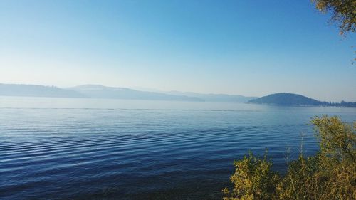 Scenic view of lake against clear blue sky