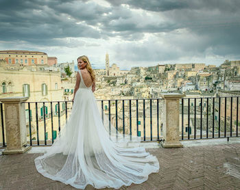 Woman standing with umbrella against sky