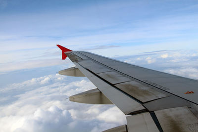 Airplane flying over clouds against sky