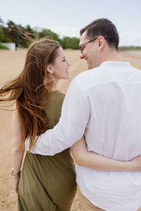 Couple of a man and a woman are walking on the beach or running along the sand along 