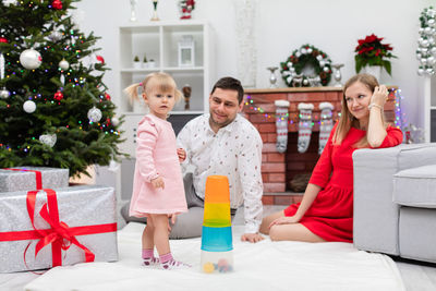 Portrait of smiling friends with christmas tree