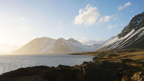 Scenic view of sea and mountains against sky